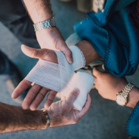 Someone bandaging a hand Someone bandaging a hand