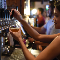 Person in bar pouring a drink