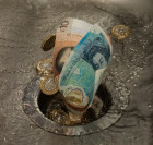 paper money going down a drain