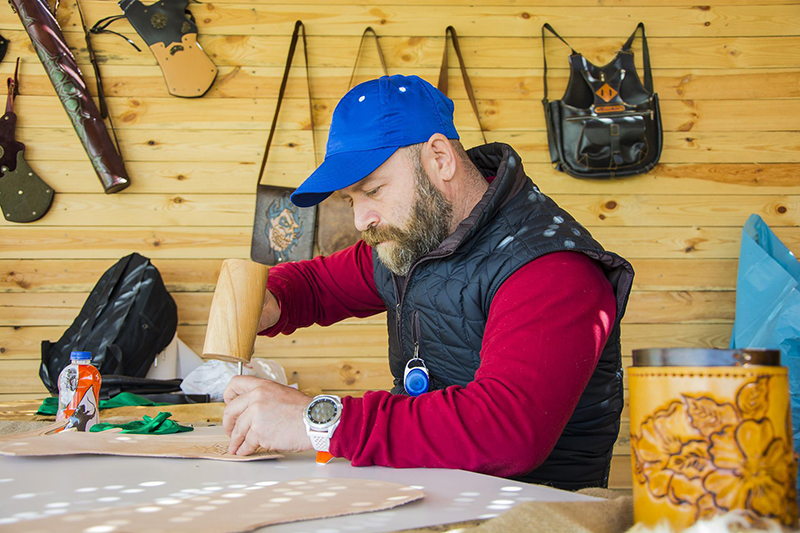 man with mallet leather working