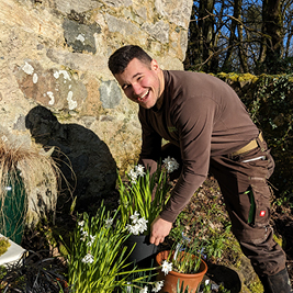 A male gardening student smiling whilst in the garden A male gardening student smiling whilst in the garden