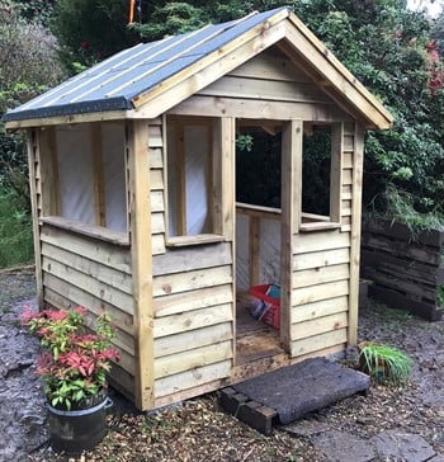 A wooden playhouse college students have build for a local outdoor nursery