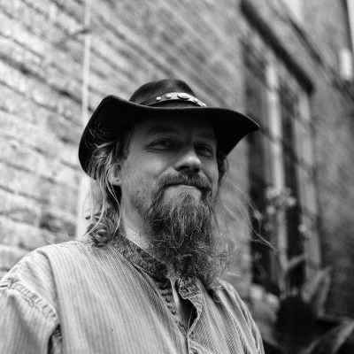 A black and white headshot of Iain Compton