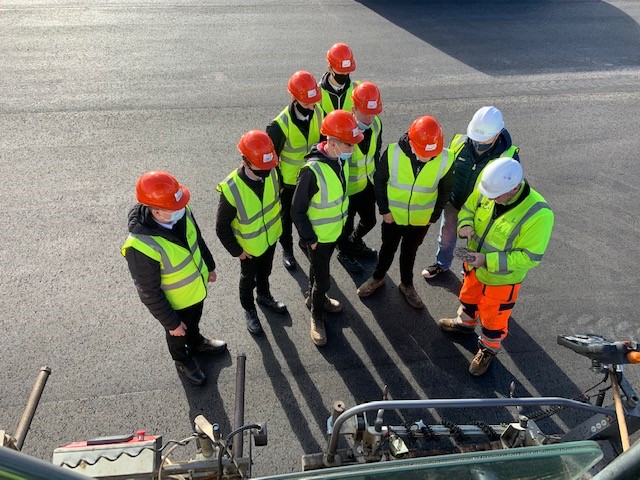 Students being shown the machinery used in an airport runway refurbishment project