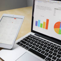 laptop and tablet showing graphs