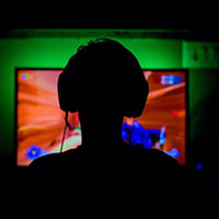 person sitting in front of a screen playing video games