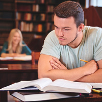 Student sat in Library reading books and working