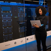 Woman working on a laptop in a datacentre