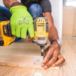 Someone drilling a screw into wood