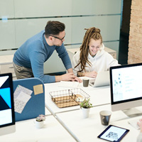 Colleagues helping each other and smiling in workplace