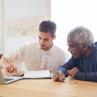Young man speaking to and older man Young man speaking to and older man