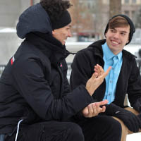 2 young men sitting and chatting to each other