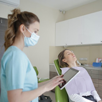 Nurse using a tablet device near a patient