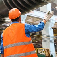 Construction worker on site wearing PPE, directing operations