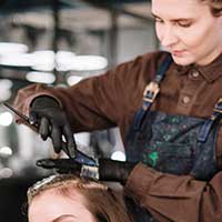 Hairdresser applying dye to a client's hair